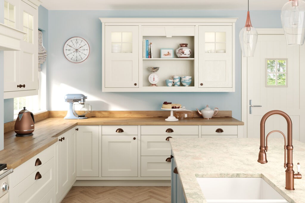 Cream shaker kitchen with pale blue walls, oak worktops and copper tap detailing